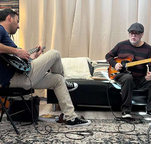 Adult students learning electric guitar during a guided lesson at PlayPro Guitar School