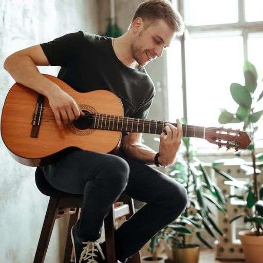 Adult student playing classical nylon string guitar using fingerstyle technique