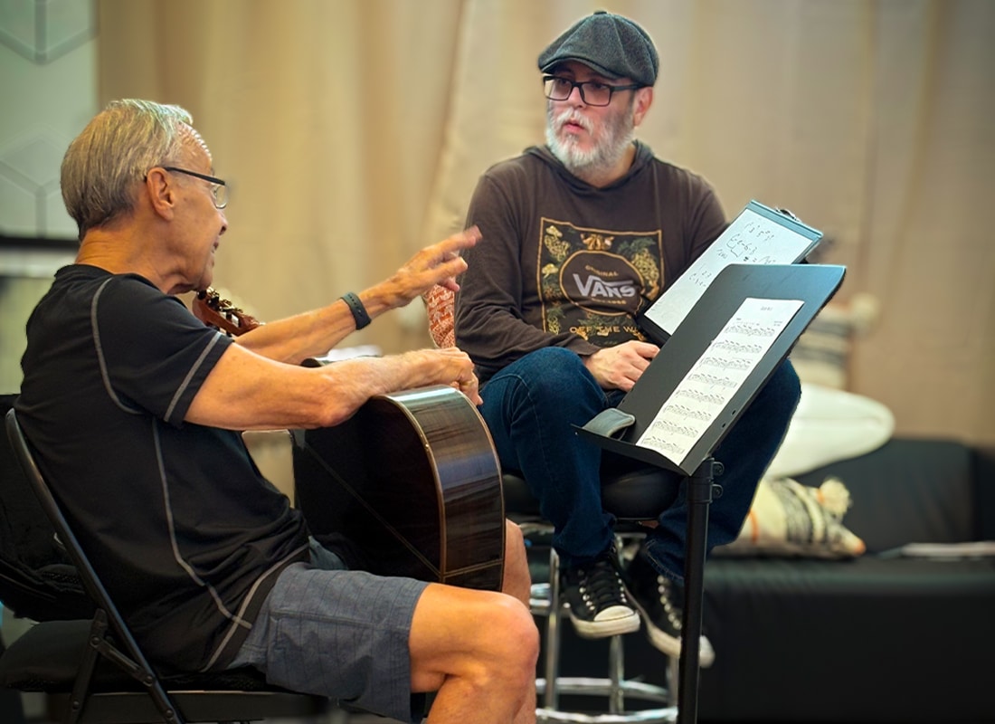 Adult guitar instructor working one-on-one with an older student during a personalized lesson