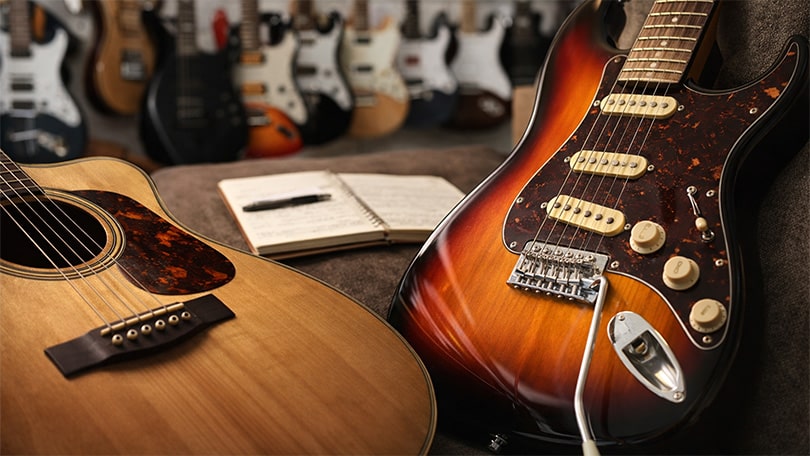 Acoustic and electric guitars with lesson notebook at PlayPro Guitar School in La Mesa Californi
