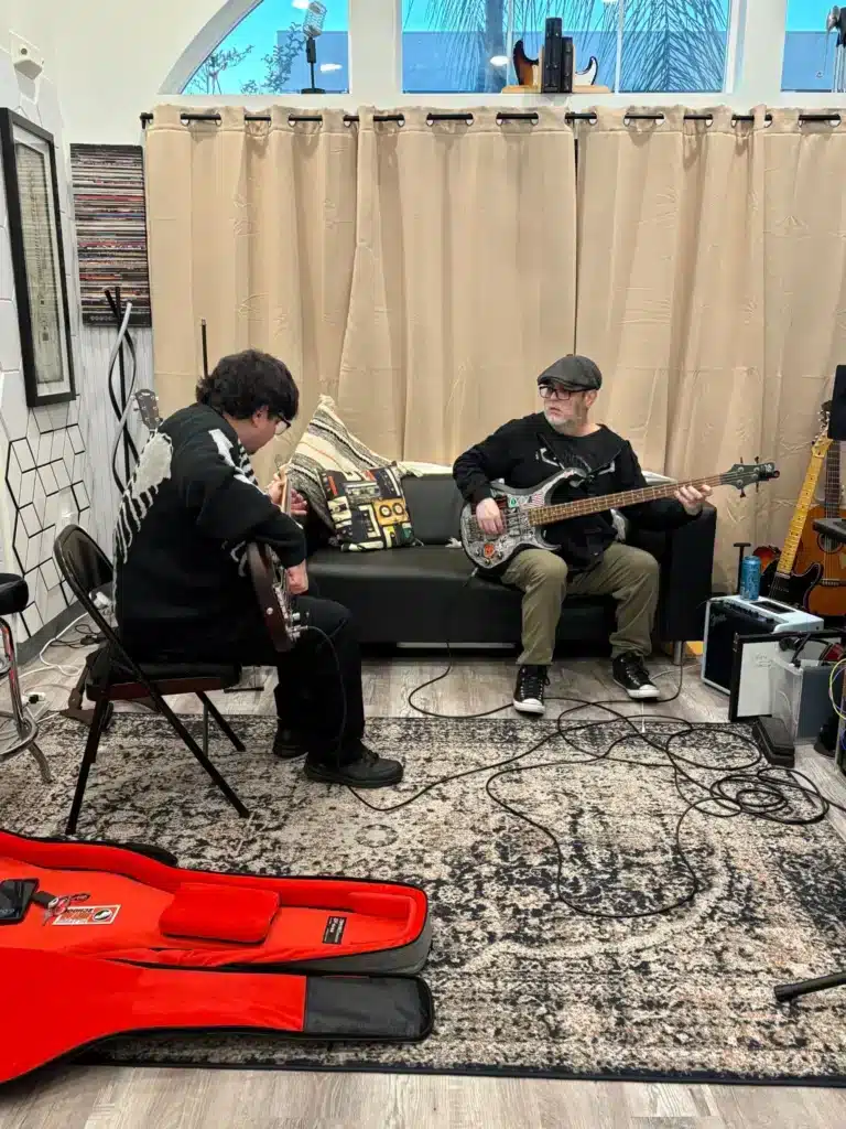 Beginner guitar student learning comfortably with an instructor at PlayPro Guitar School in La Mesa